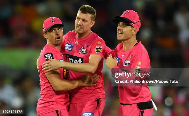 Steve O'Keefe , Jake Ball and Daniel Hughes of Sydney Sixers celebrate the dismissal of Ben Cutting during the Big Bash League match between the...