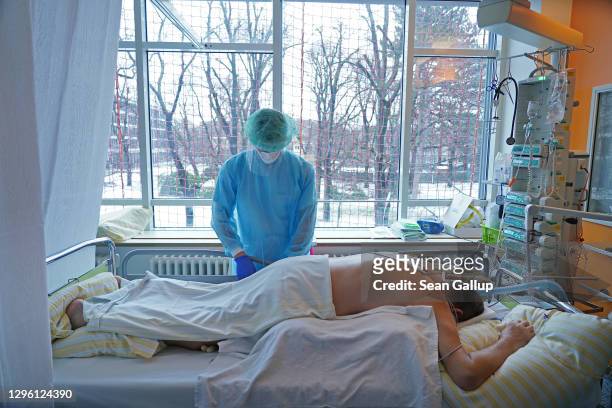 Nurse tends to a Covid patient who is lying on his stomach to help him breathe in the Covid intensive care unit at Leipzig university hospital during...