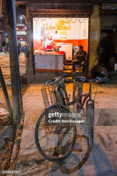 kathmandu bicycles and butcher shop illuminated street at night nepal - nepal road stock pictures, royalty-free photos & images