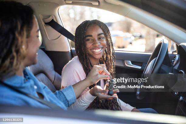 mother handing car keys to teenage daughter - car ownership fotografías e imágenes de stock