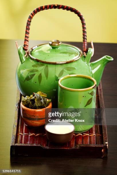 green tea leaves with pot - green tea stock-fotos und bilder