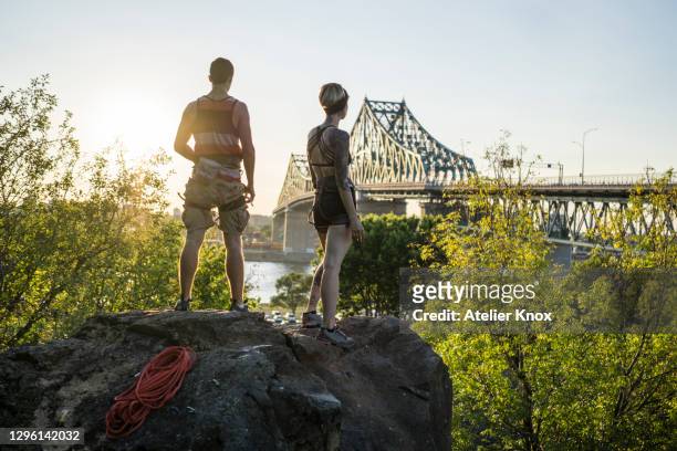 two friends rock climbing together drinking water and taking a break - montreal people stock pictures, royalty-free photos & images