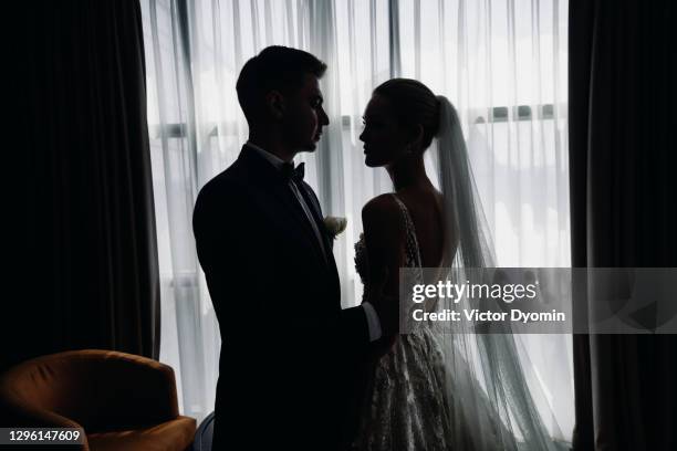 indoor portrait of the passionate bride and groom - married silhouette stock pictures, royalty-free photos & images