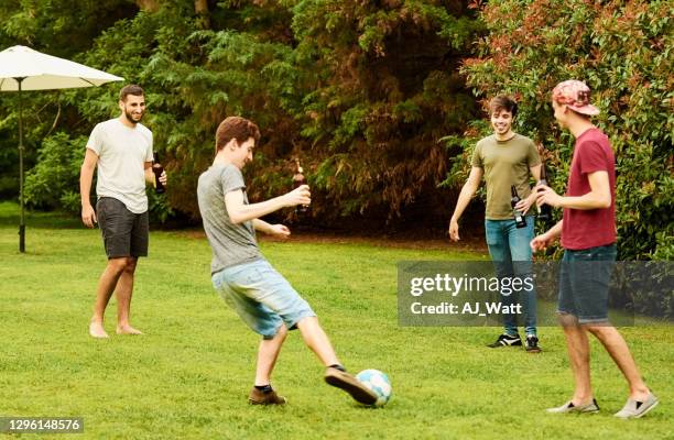 freunde am wochenende spielen ein spiel auf fußball in hinterhof garten - backyard football stock-fotos und bilder