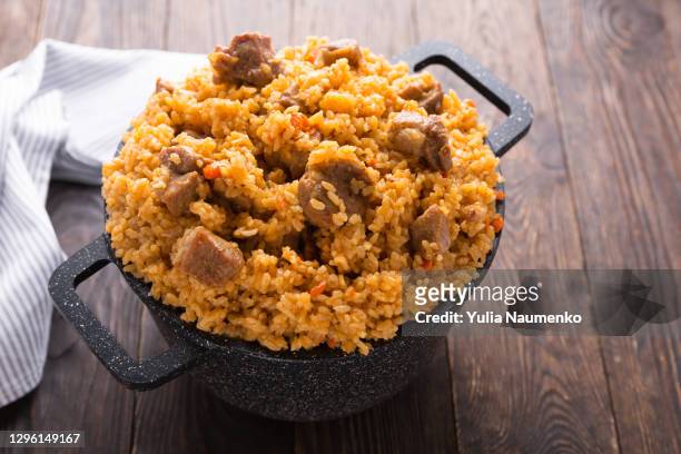 pilaf in a cast-iron cauldron. rice dish. - pilafrijst stockfoto's en -beelden