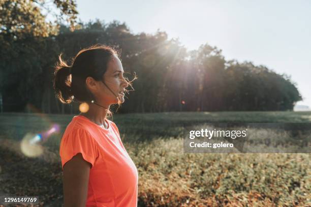 sportswoman standing in the sunny landscape - running lights stock pictures, royalty-free photos & images