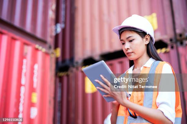 female customs holding touchpad in cargo container while examining container by customs application process during import and export. freight forwarder business concept. - 通関士 ストックフォトと画像