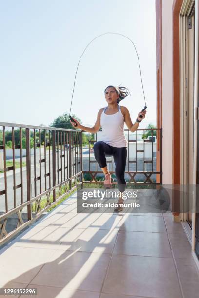 beautiful young athlete using a skipping rope during an outdoor training session at her balcony - mexico training session stock pictures, royalty-free photos & images