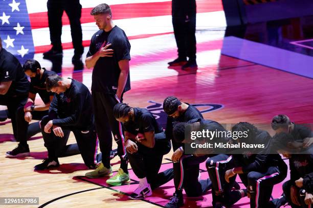 Members of the Miami Heat kneel during the playing of the national anthem, as Meyers Leonard stands, prior to the game against the Boston Celtics at...