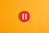 Red round circle with a pause button or icon