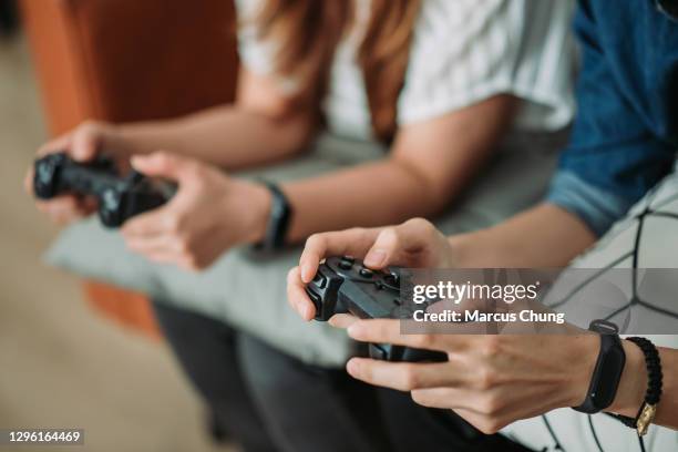 chinês asiático sorrindo irmão jogando videogame em casa - joystick - fotografias e filmes do acervo