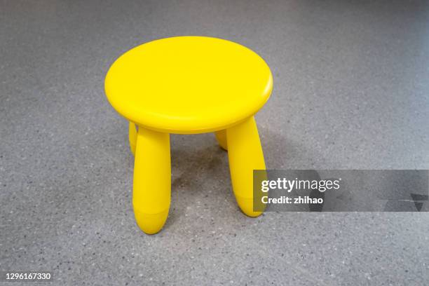 yellow small chair on cement floor - tabouret photos et images de collection