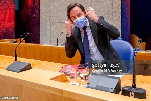 Prime minister Mark Rutte puts on a face mask during the debate about the coronavirus measures in the Tweede Kamer parliament on January 13, 2021 in...