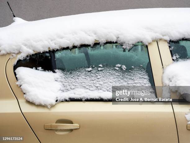car parked on the street covered with snow. - storm outside window stock pictures, royalty-free photos & images