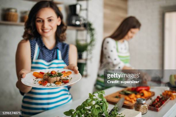 giovani donne che preparano cibo in cucina - mostrare foto e immagini stock