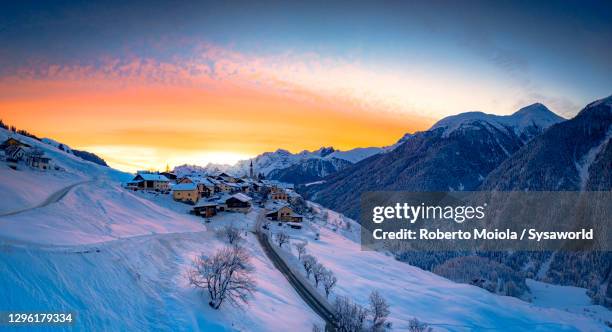sunrise on snowy village of guarda in winter, switzerland - guarda sol stock-fotos und bilder