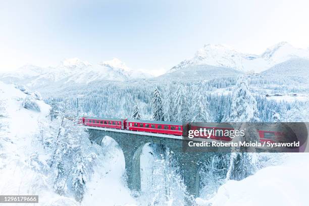 bernina express train in white winter snowy landscape - express photos et images de collection