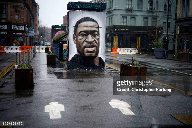 Social distance markers adorn the deserted pavement in front of a mural of George Floyd in Manchester during lockdown three on January 13, 2021 in...