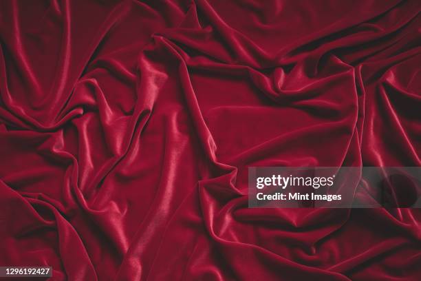 detail of crumpled red velvet fabric - velvet stockfoto's en -beelden