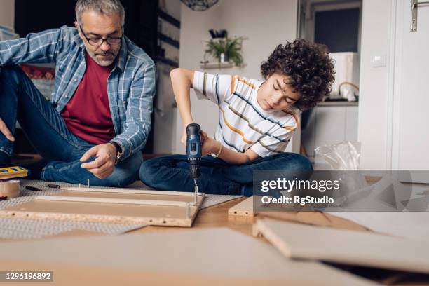 boy enjoying with his father while making wooden furniture at home - fathers day tools stock pictures, royalty-free photos & images