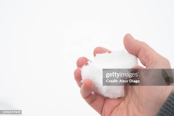 a man makes a snowball in winter. - bevriezing stockfoto's en -beelden