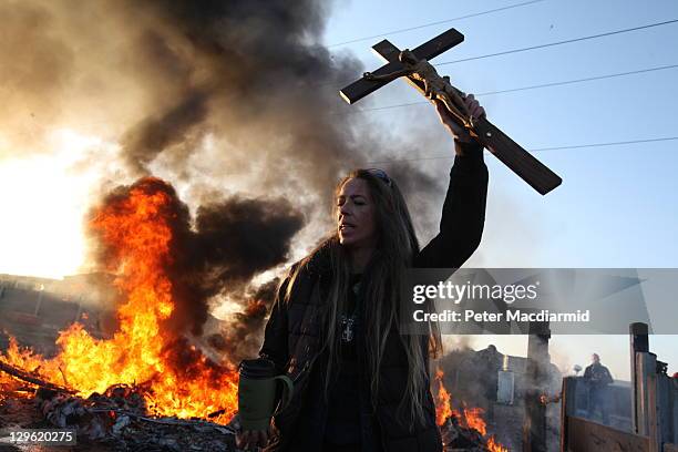 An activist holds up a crucifix as a barricade burns during evictions from Dale Farm travellers camp on October 19, 2011 near Basildon, England....