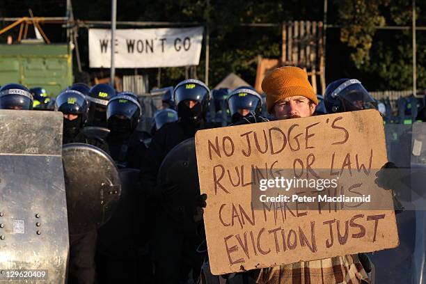 An activist holds up a placard in front of a police line during evictions from Dale Farm travellers camp on October 19, 2011 near Basildon, England....