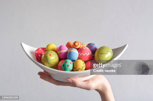 de hand die van de vrouw mand met geschilderde eieren houdt - easter and humour stockfoto's en -beelden