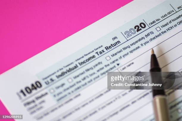 close up of tax form 1040 for year 2020 on pink background - filing documents stock pictures, royalty-free photos & images