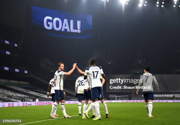 Harry Kane of Tottenham Hotspur celebrates with teammates Harry Winks and Moussa Sissoko after scoring their team's first goal during the Premier...