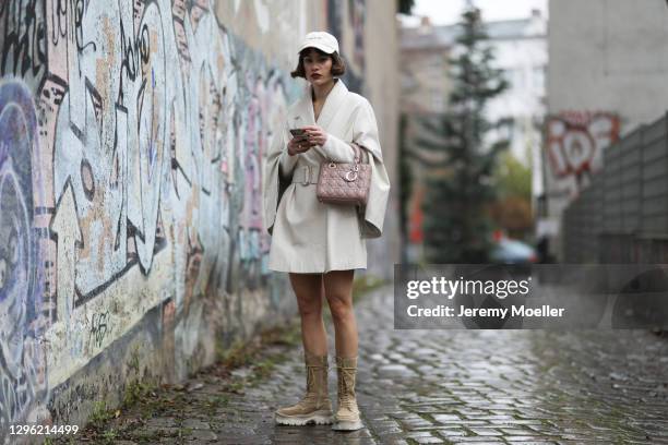 Lea Naumann wearing Nobi Talai coat, Dior bag, Zalando boots and can’t decide clothing cap on January 12, 2021 in Berlin, Germany.