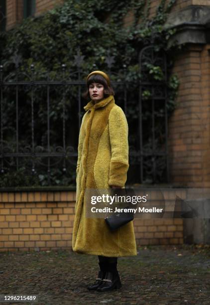 Lea Naumann wearing Fassbender coat, Zalando shoes, Prada bag, Marzoline Milano hairband on January 12, 2021 in Berlin, Germany.