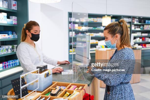 pharmacist charging the client for the medicine - generikum stock-fotos und bilder