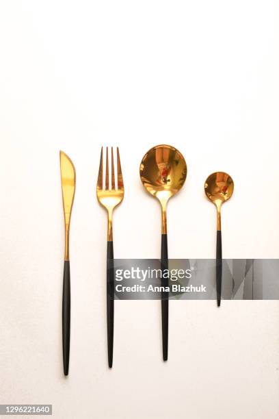 black and golden cutlery, knife, spoons and fork with copy space over white background - silverware fotografías e imágenes de stock