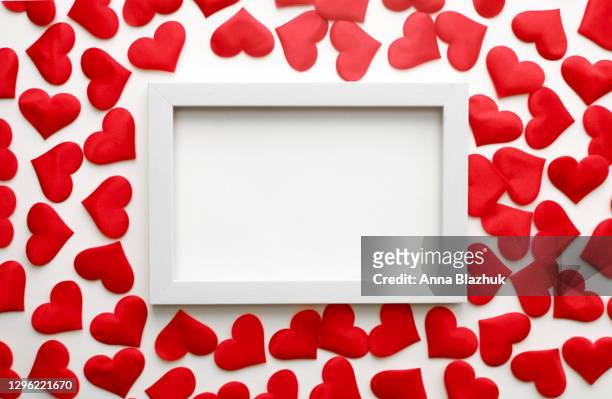 confetti of many red hearts and white frame over white background. valentine's day greeting card. - heart shape frame stock-fotos und bilder