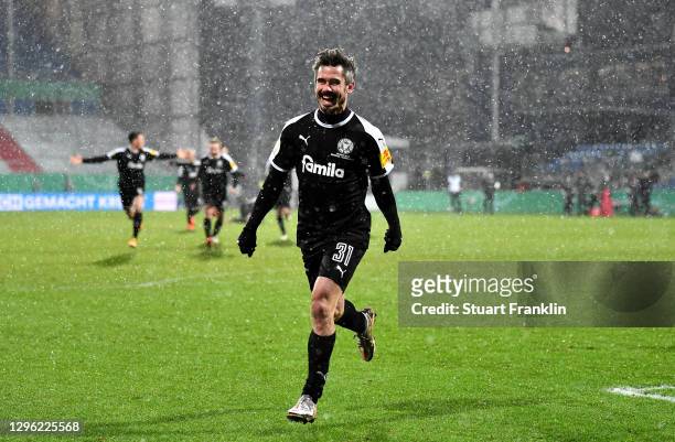 Fin Bartels of Holstein Kiel celebrates after winning the penalty shootout during the DFB Cup second round match between Holstein Kiel and Bayern...