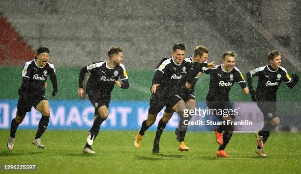 Lee Jae-Song of Holstein Kiel and teammates run to celebrate after winning the penalty shootout during the DFB Cup second round match between...