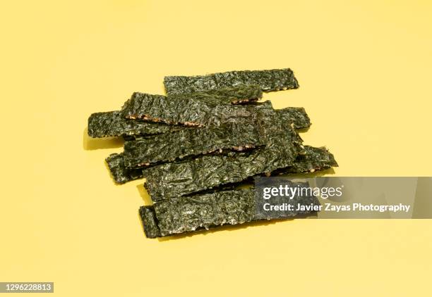 seaweed snack on yellow background - alga marina fotografías e imágenes de stock