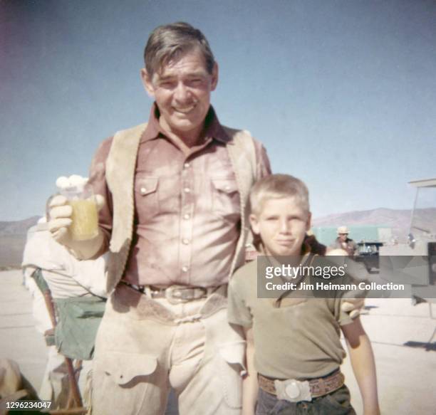 Photo shows Clark Gable on the set of The Misfits, which starred Marilyn Monroe, posing for a picture with his stepson, Bunker Spreckels in between...
