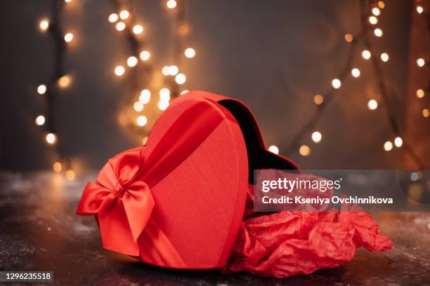 valentine's day, gift box of kraft paper with a red ribbon and candles. rustic style - heart box ribbon stockfoto's en -beelden