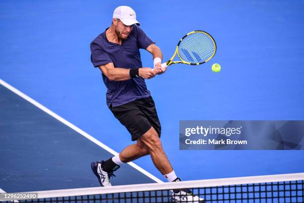 Christian Harrison returns a shot against Ariel Behar of Uruguay and Gonzalo Escobar of Ecuador while playing with his brother Ryan Harrison during...