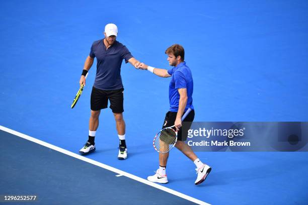 Christian and Ryan Harrison fist bump after scoring a point against Ariel Behar of Uruguay and Gonzalo Escobar of Ecuador during the Doubles Finals...