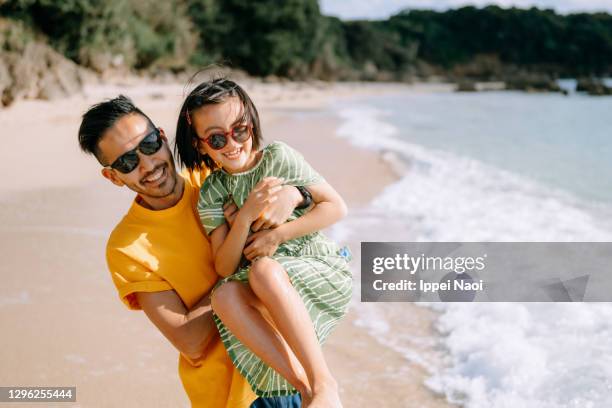 father and young daughter having fun on beach, japan - eltern sonnenbrille sonne lachen stock-fotos und bilder