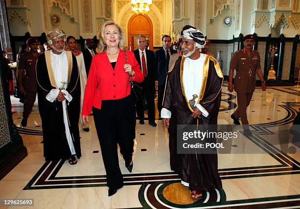 Secretary of State Hillary Clinton walks with Sultan Qaboos bin Said upon her arrival at the sultan's palace for lunch in Muscat on October 19, 2011....