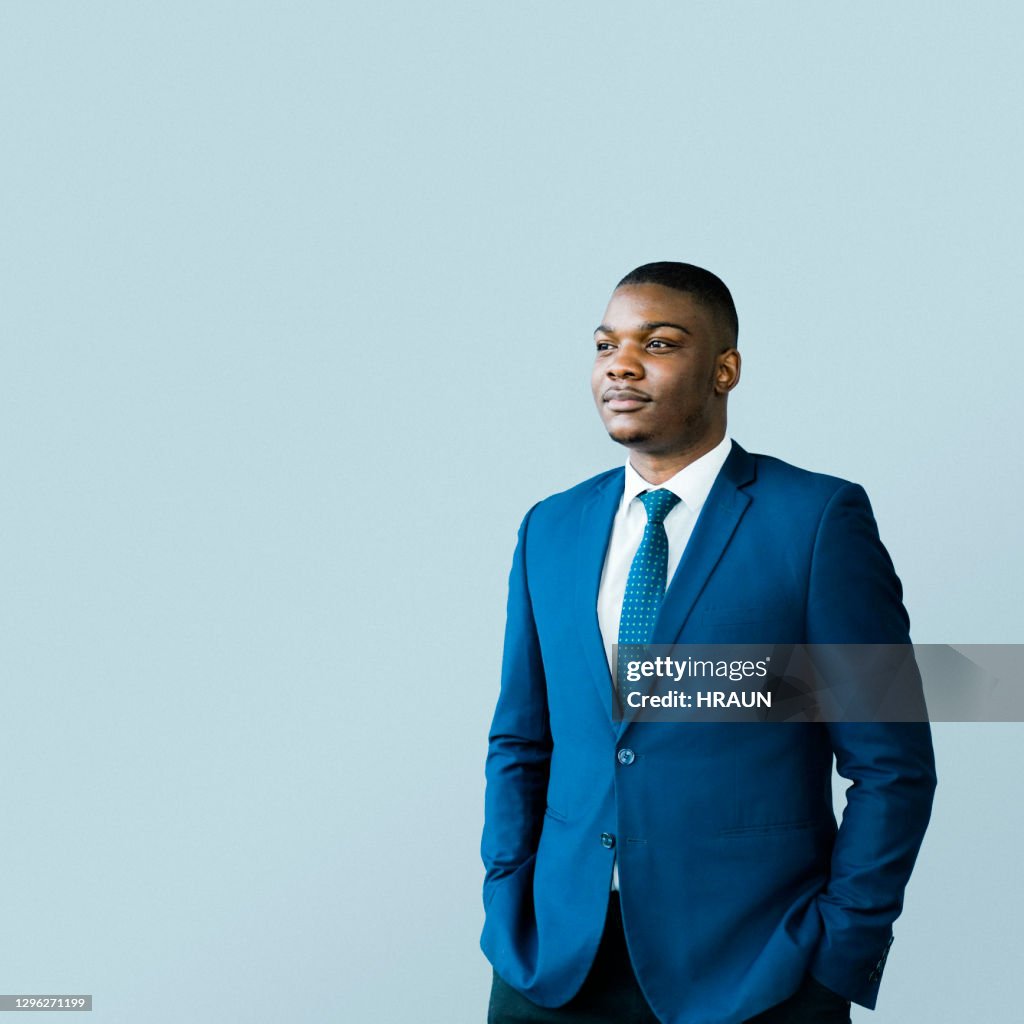 Thoughtful male CEO standing with hands in pockets