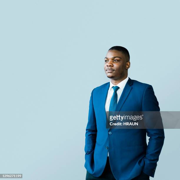 thoughtful male ceo standing with hands in pockets - three quarter length stock pictures, royalty-free photos & images