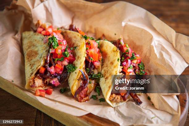 在木盤的棕色紙上用切碎的烤豬肉和乳酪餡來供應玉米餅 - taco 個照片及圖片檔