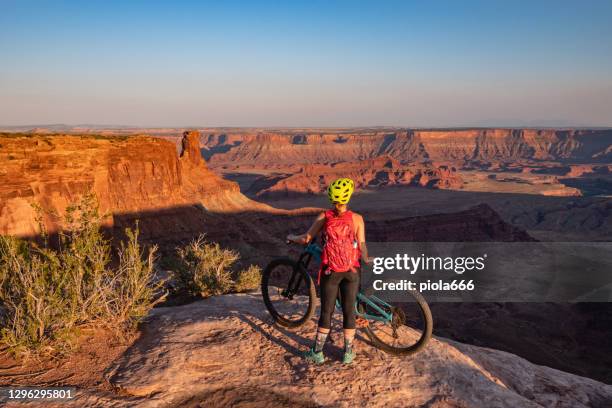 reizen in usa southwest: vrouw mountainbiking in moab, utah - moab utah stockfoto's en -beelden