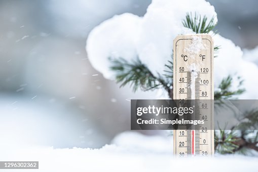 Thermometer in the snow shows low temperatures in Celsius and Farenhaits. Thermometer in the snow shows low temperatures in Celsius and Farenhaits.