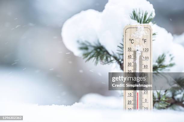 thermometer in the snow shows low temperatures in celsius and farenhaits. - weather improve in kashmir after two days of snowfall stockfoto's en -beelden